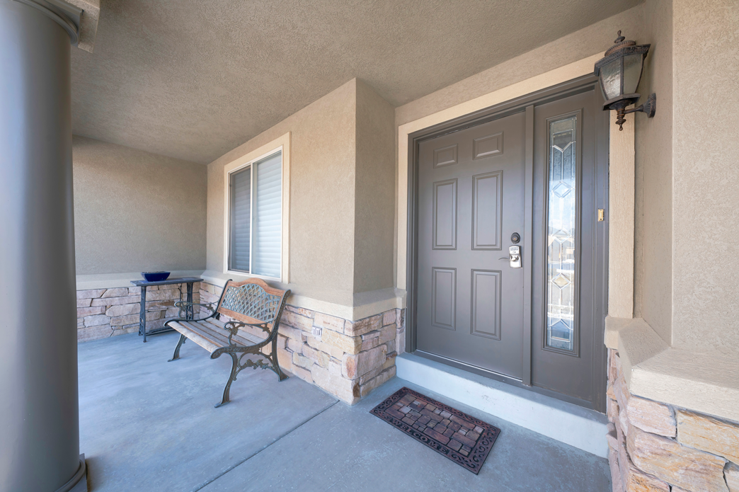 Pose de portes d'entrées à Hébécourt | DJS Fermetures Entrée d'une maison avec une porte marron et un banc en bois à côté.