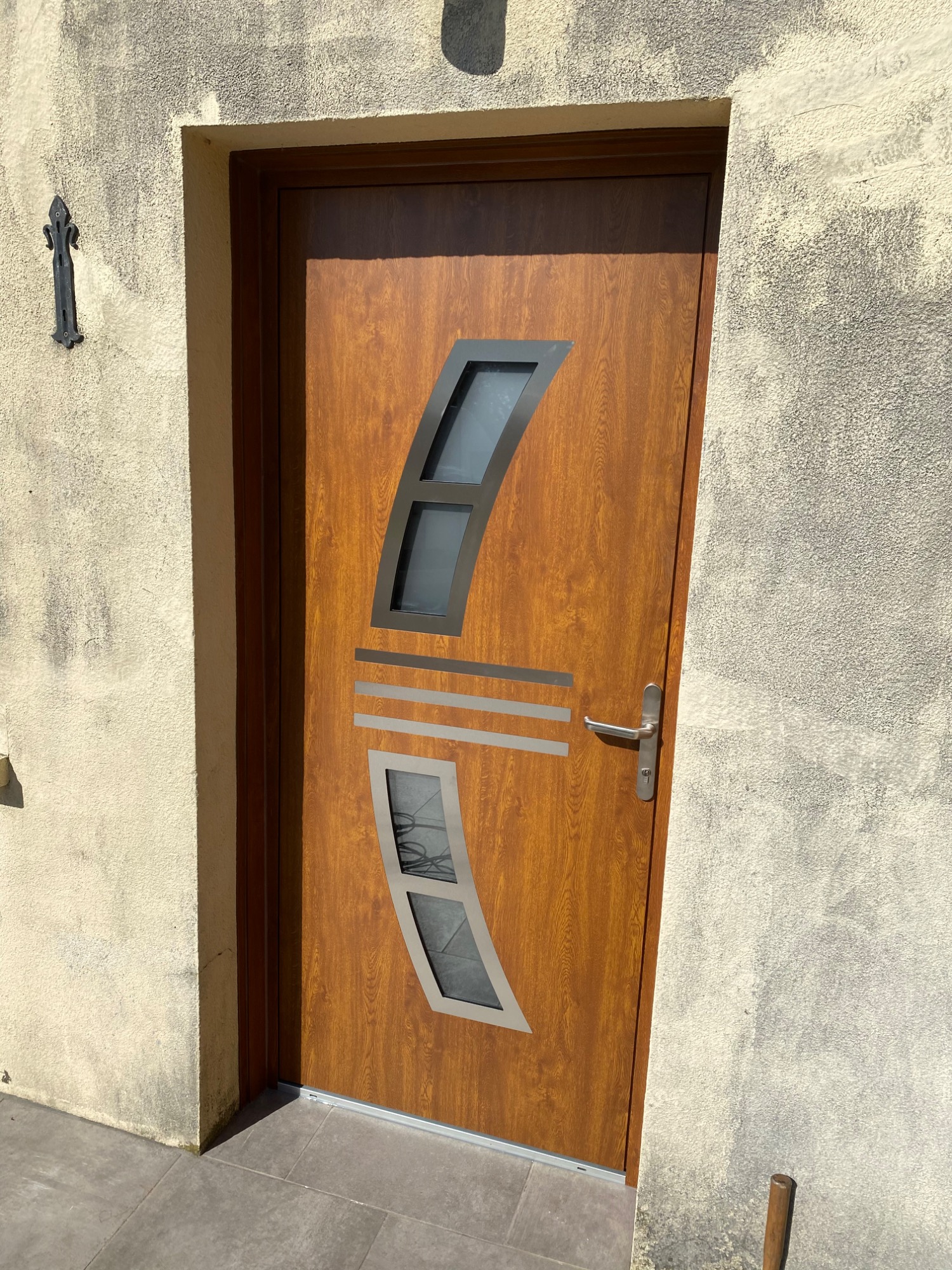 Porte en bois avec un design moderne et des inserts en verre.